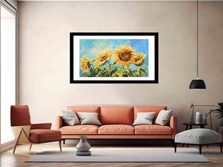 Framed painting of sunflowers on a wall above a sofa in a living room.