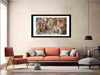 Framed artwork of a village scene above an orange sofa in a living room.