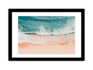 Framed artwork of a beach scene with turquoise water and pink sand.