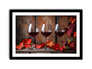 Three wine glasses with red wine on a wooden surface with autumn leaves and berries.