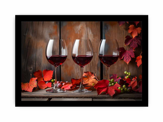 Three wine glasses with red wine on a wooden surface with autumn leaves and berries.