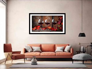 Framed artwork of wine glasses and flowers on a wall above an orange sofa in a living room.