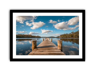 Framed photograph of a wooden dock extending into a calm lake with a blue sky and clouds.
