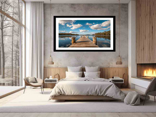 Framed landscape print of a dock over water in a bedroom setting.
