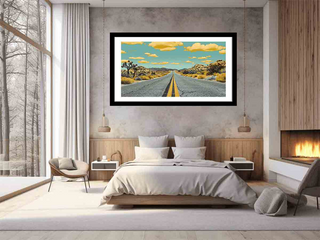 Framed artwork of a road with mountains on a wall in a bedroom.