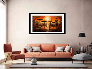 Framed artwork of a sunset over a savanna with people and animals, hanging above a sofa in a living room.