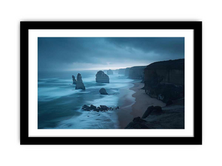 Framed artwork of a coastal scene with cliffs and ocean at night.