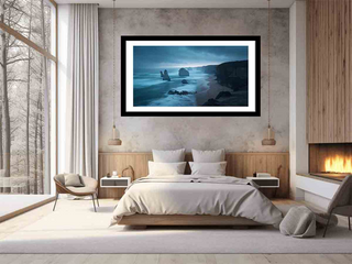 Modern bedroom with a large framed artwork of a coastal scene on the wall.