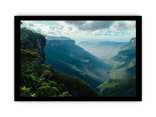 Framed photograph of a mountainous landscape with greenery and a cloudy sky.