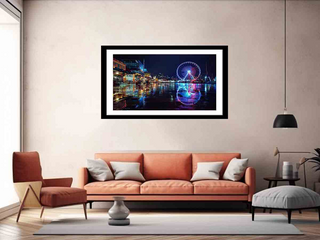 Framed artwork of a cityscape with Ferris wheel in a living room.