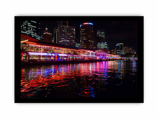 City skyline at night with colorful reflections on water