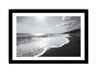 Black and white framed beach scene with waves and sky.