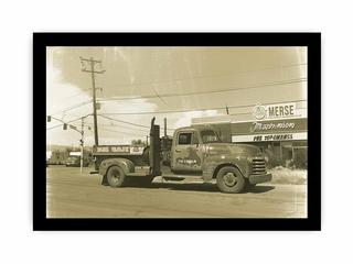 Vintage truck parked on a street with a building in the background