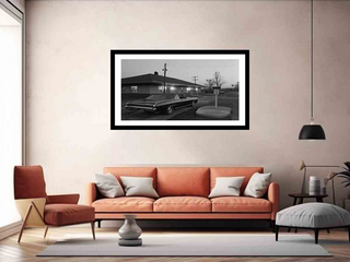Living room with an orange sofa, armchair, and framed black and white photograph on the wall.