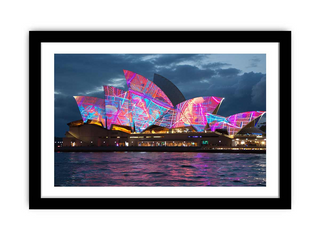 Framed artwork of the Sydney Opera House with colorful lights against a dark sky.
