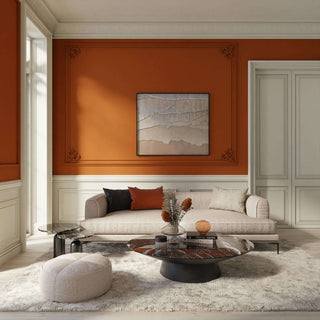 Modern living room with orange walls, a gray sofa, and decorative elements.