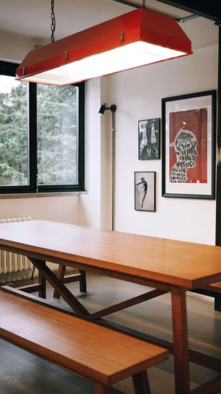 Modern dining room with a wooden table and red pendant light.