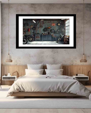Framed artwork of a motorcycle garage on a wall above a bed in a bedroom.